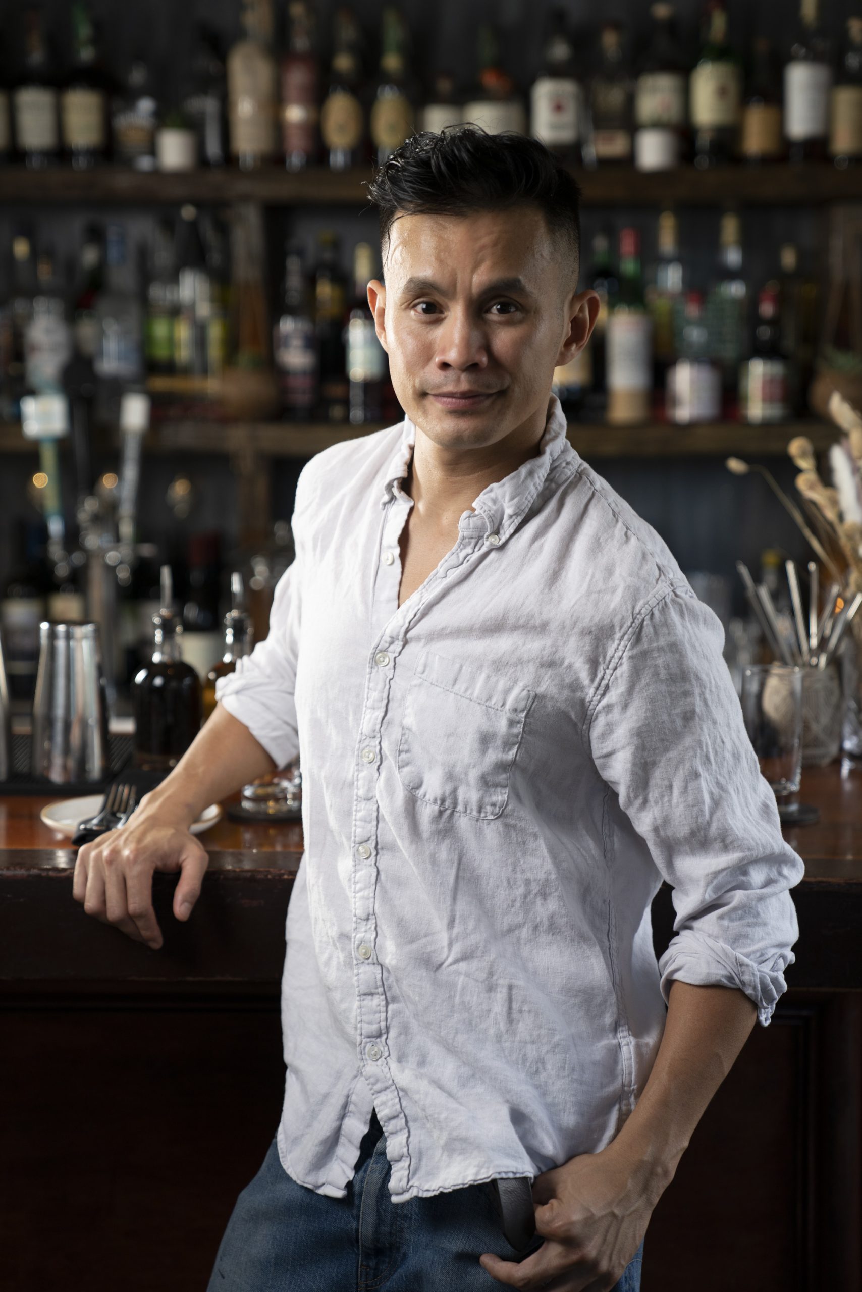 Photo portrait of general manager Leo Mamaril Jr. standing in front of the bar inside of the restaurant