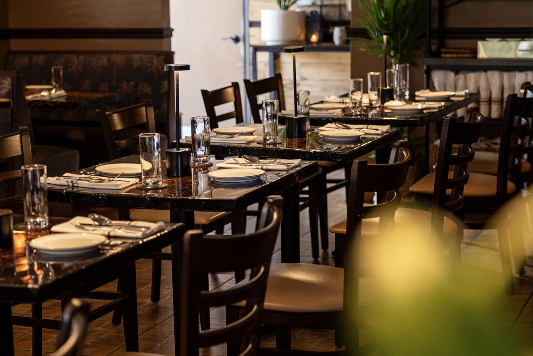 Photo of empty tables in the dining room set for dinner service